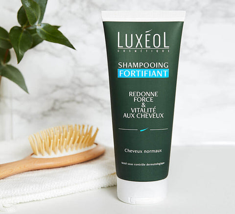Strengthening Shampoo lifestyle beside brush and towel; use 2–3 times weekly, massage, rinse well.